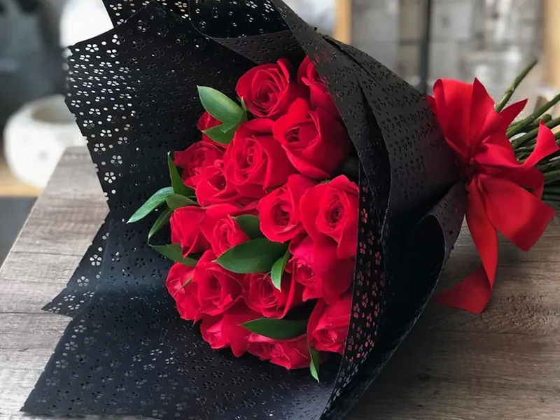 Bouquet of red roses wrapped in black lace paper