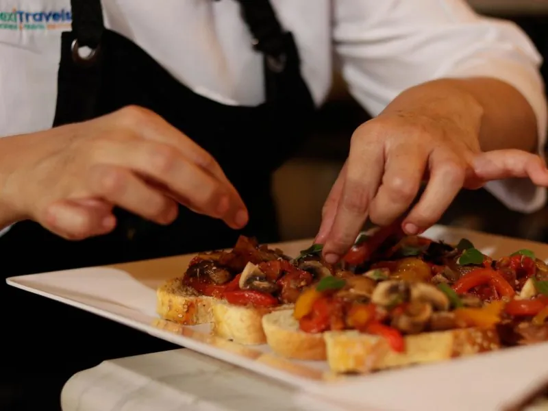 Chef plating bruschetta with fresh tomato