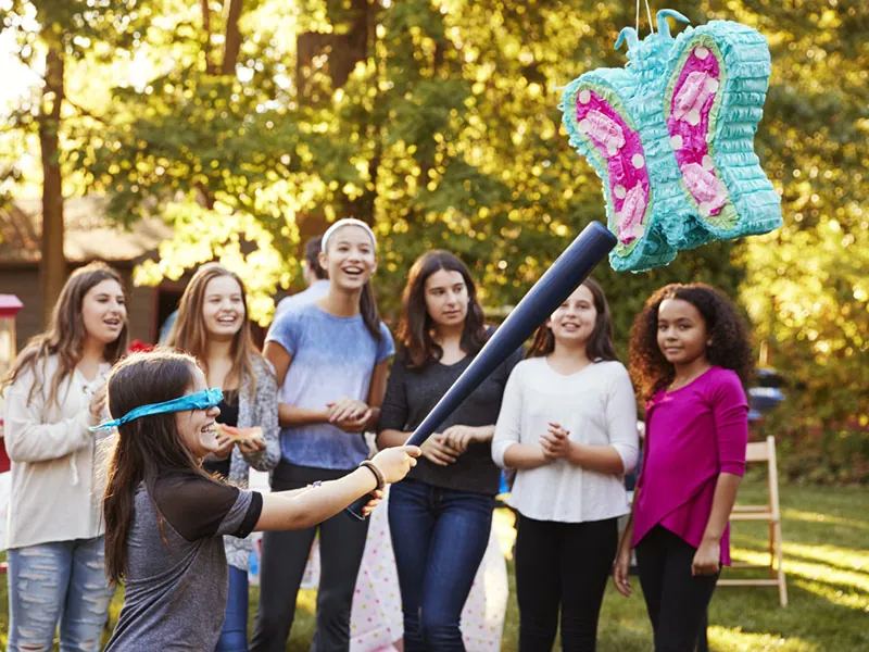 Children at a garden party with a piñata