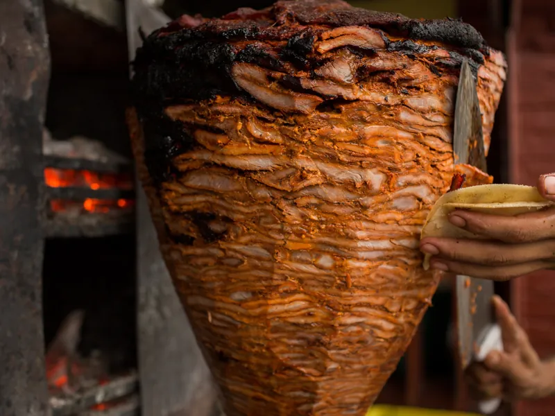 Close-up of a glowing al pastor spit