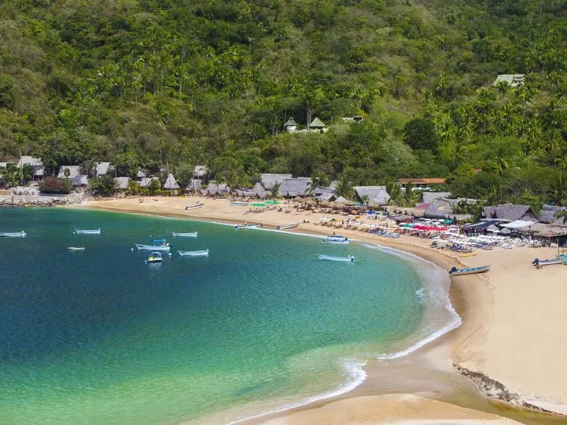 Crescent of Majahuitas beach with turquoise water and jungle behind