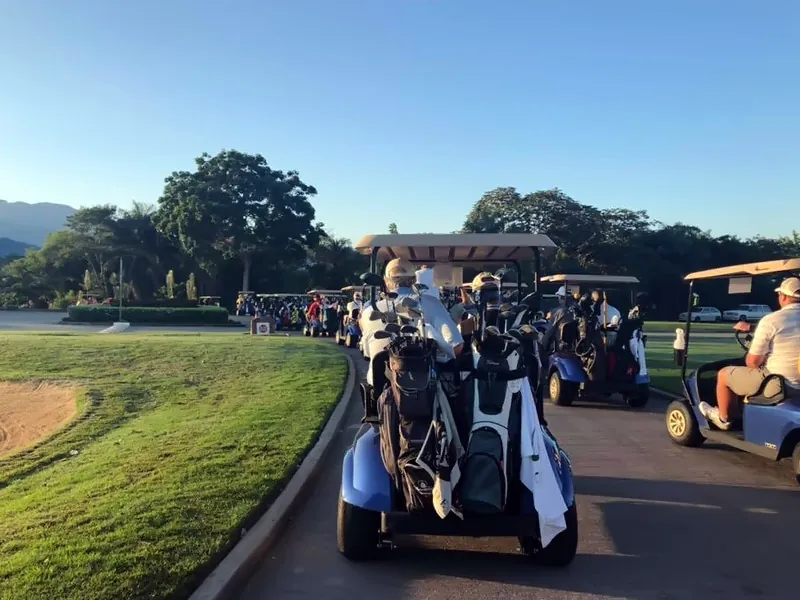 Golf cart with clubs on the cart path