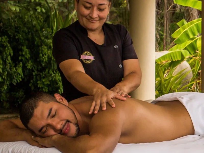 Guest smiling during a back massage outdoors