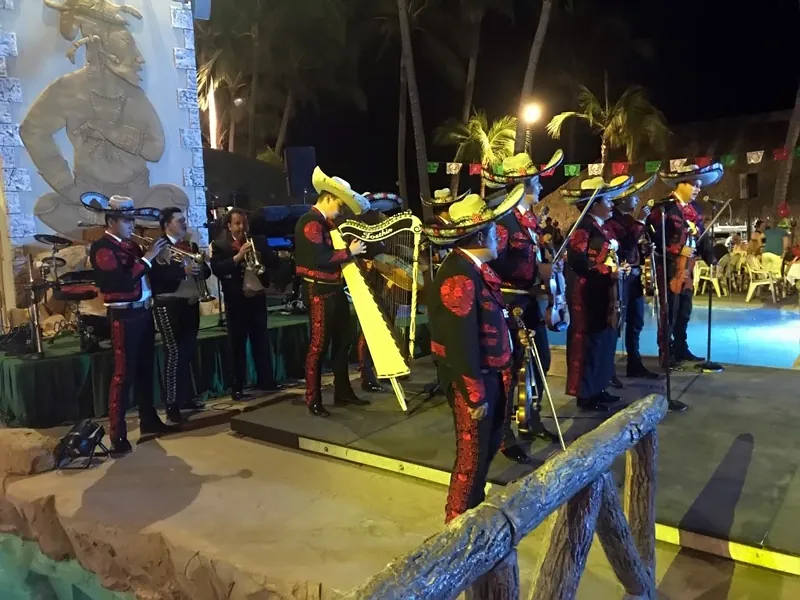Mariachi performing at a lit poolside party
